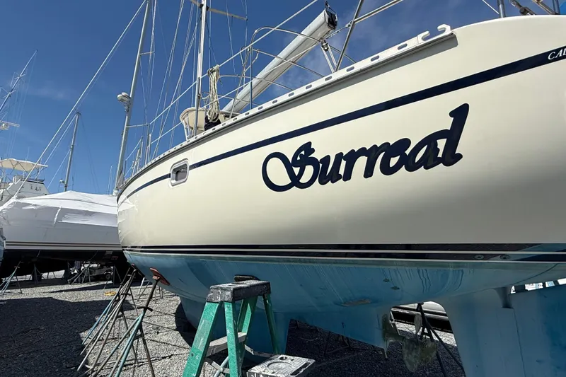 Slide: The Image of Caliber 47LRC 2001 sailboat named "Surreal" on dry dock under clear blue sky. - 2