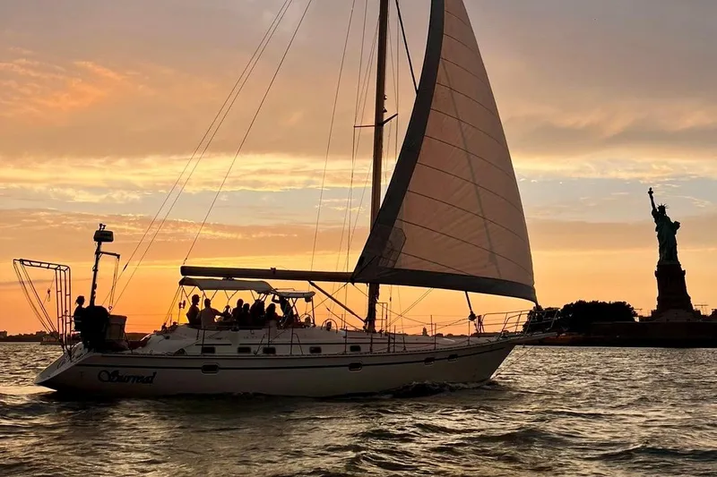 Slide: The Image of Sailboat Caliber 47LRC 2001 cruising near Statue of Liberty at sunset. - 25