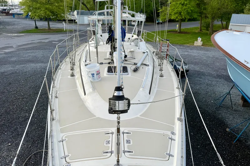 Slide: The Image of Sailboat deck of 2001 Caliber 47LRC, docked on gravel with lush greenery. - 5