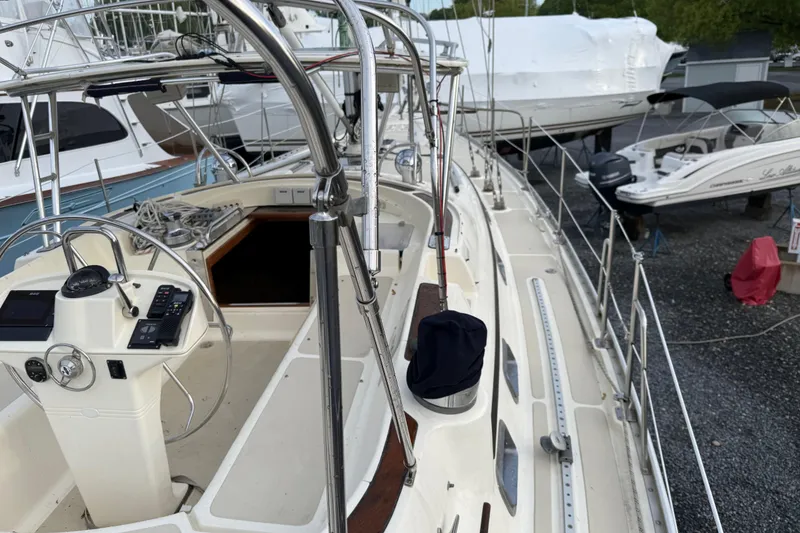 Slide: The Image of Sailboat Caliber 47LRC 2001 with steering wheel and deck view in a marina setting. - 7