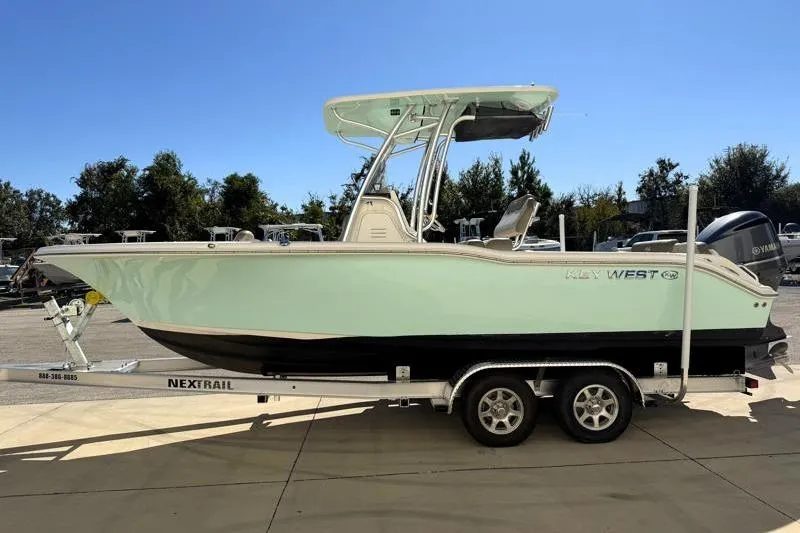 Slide: The Image of 2024 Key West 239 FS boat on trailer, side view, outdoors. - 2