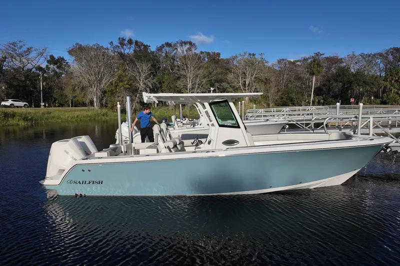Slide: The Image of 2026 Sailfish 272 CC boat docked on a calm lake under a clear blue sky. - 3