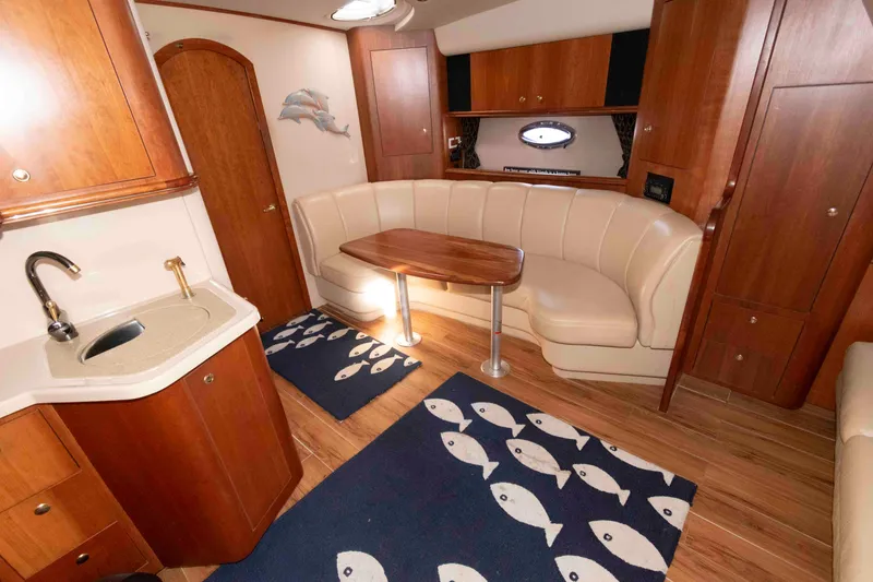 Slide: The Image of Interior of 2001 Cruisers Yachts 3672 Express with wood cabinetry and cozy seating area. - 12