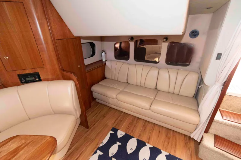 Slide: The Image of Interior of 2001 Cruisers Yachts 3672 Express with beige seating and wooden accents. - 13