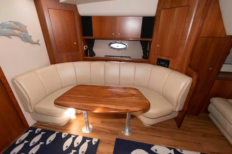 Slide: The Image of 2001 Cruisers Yachts 3672 Express interior with curved seating and wooden table. - 14