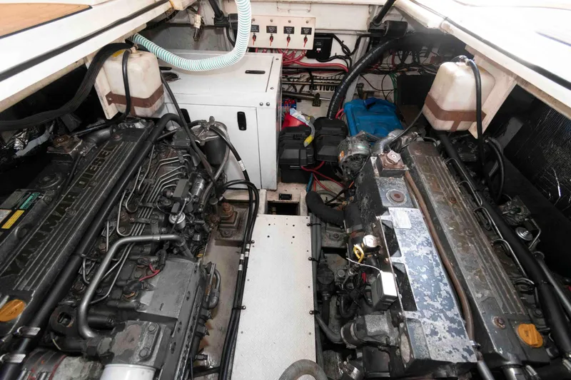 Slide: The Image of Engine room of 2001 Cruisers Yachts 3672 Express, showcasing dual diesel engines and wiring. - 17
