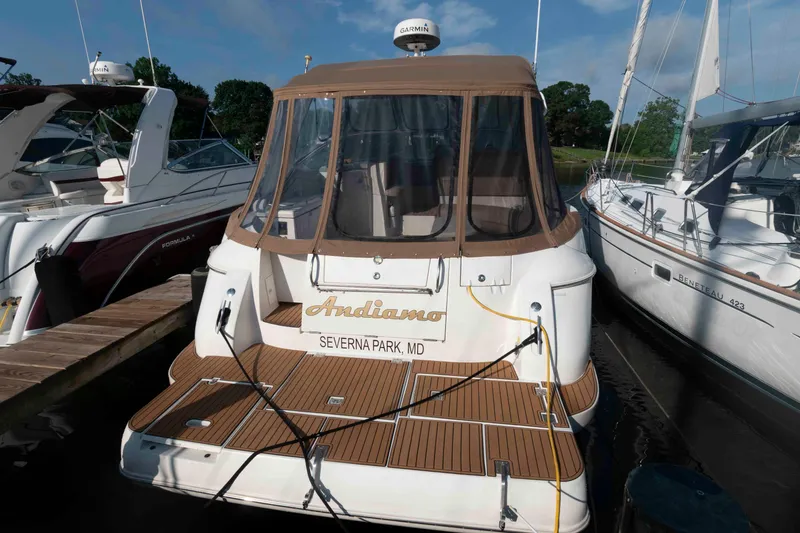 Slide: The Image of 2001 Cruisers Yachts 3672 Express docked, featuring a covered deck and wooden flooring. - 2