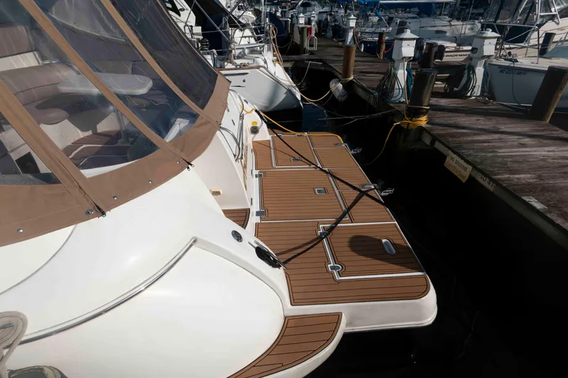 Slide: The Image of 2001 Cruisers Yachts 3672 Express docked at marina, featuring teak swim platform. - 3