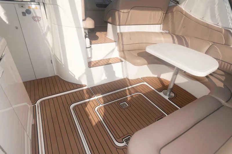 Slide: The Image of 2001 Cruisers Yachts 3672 Express interior with teak flooring and beige seating. - 4