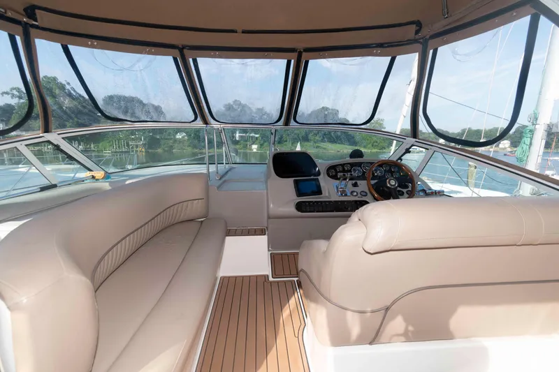 Slide: The Image of 2001 Cruisers Yachts 3672 Express cockpit with beige seating and control panel. - 7
