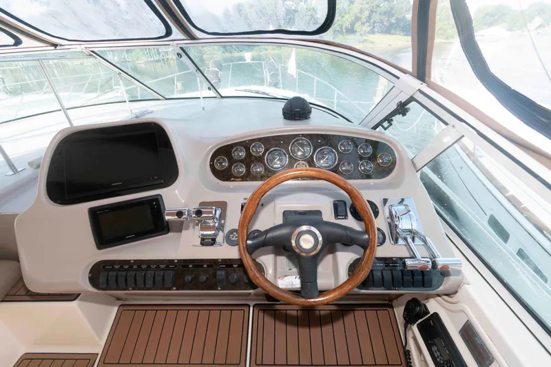 Slide: The Image of 2001 Cruisers Yachts 3672 Express helm with wooden steering wheel and control panel. - 9