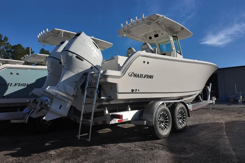 Slide: The Image of 2026 Sailfish 272 CC boat on trailer with dual engines, parked outdoors. - 2