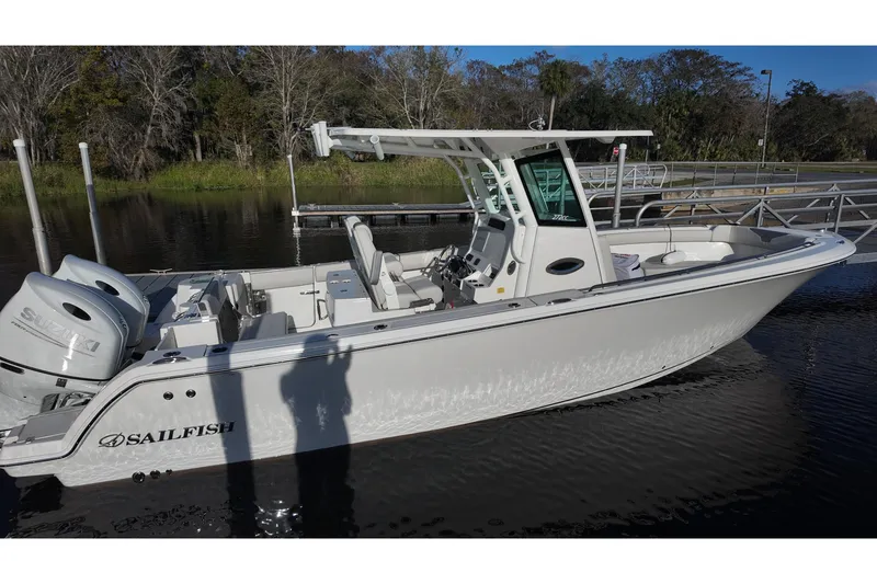 Slide: The Image of 2026 Sailfish 272 CC boat docked, featuring dual Suzuki engines and sleek design. - 3