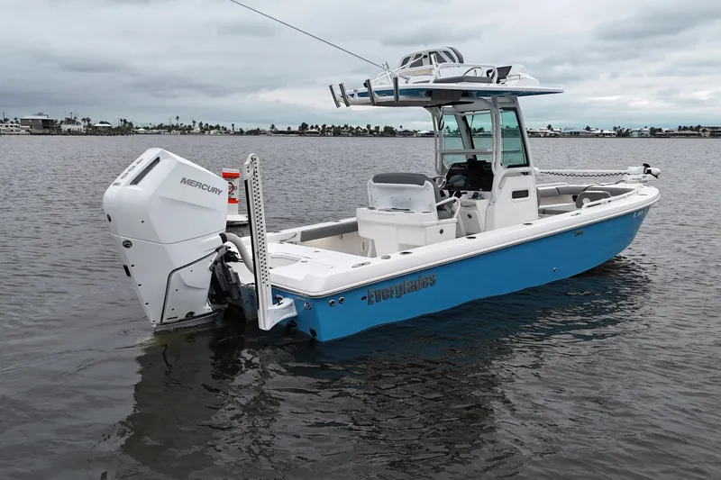 Slide: The Image of 2024 Everglades 253 Center Console boat on calm water, featuring a Mercury engine. - 21