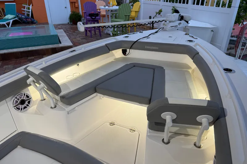 Slide: The Image of 2024 Everglades 253 Center Console boat interior with cushioned seating and ambient lighting. - 23