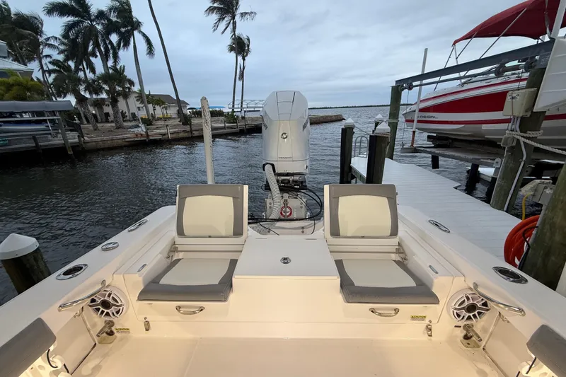 Slide: The Image of 2024 Everglades 253 Center Console boat docked, featuring comfortable seating and powerful outboard motor. - 27