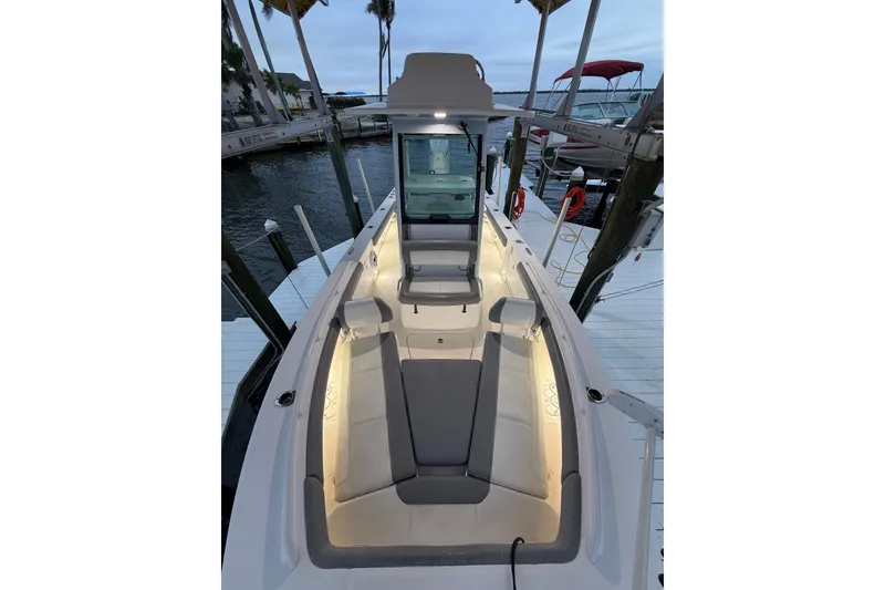Slide: The Image of 2024 Everglades 253 Center Console boat docked, featuring illuminated seating and sleek design. - 29