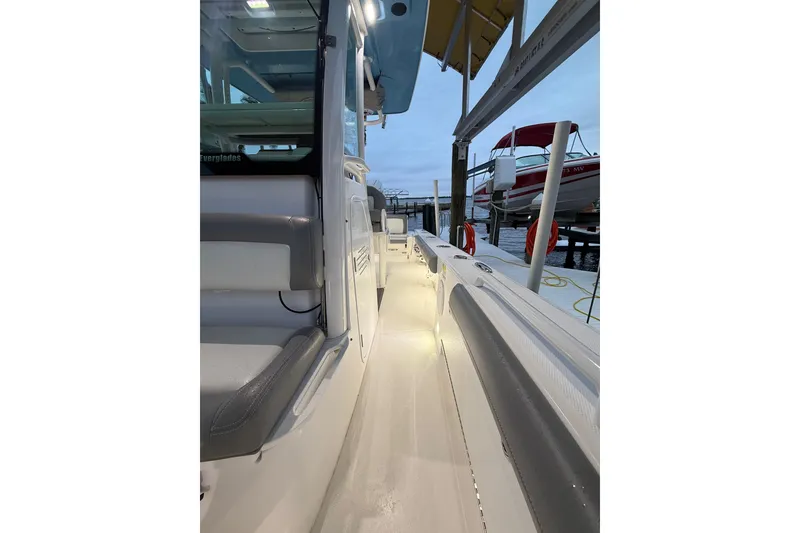 Slide: The Image of 2024 Everglades 253 Center Console boat docked, featuring illuminated walkway and seating. - 31
