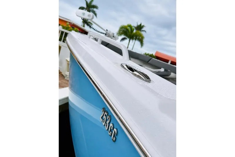 Slide: The Image of 2024 Everglades 253 Center Console boat, close-up view, docked with palm trees in background. - 36