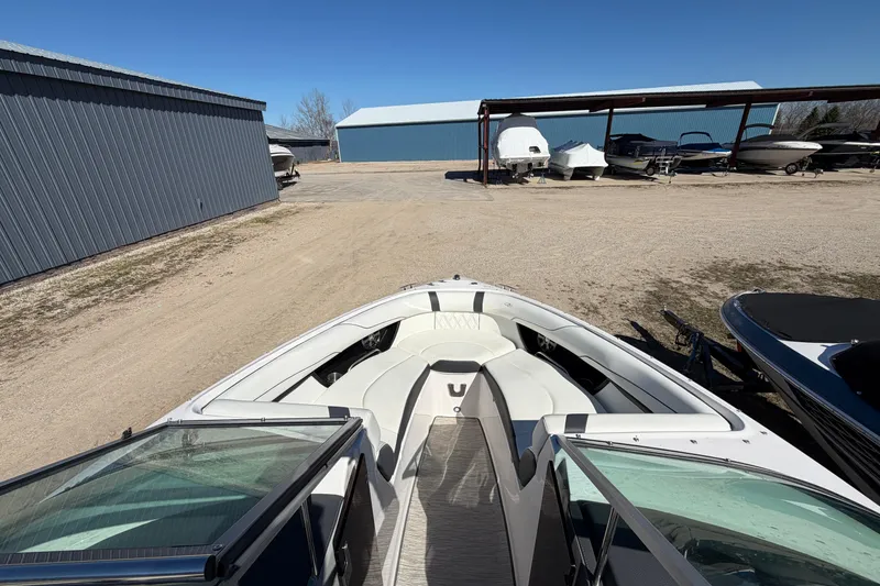 Slide: The Image of 2019 Regal 2300 Bowrider boat parked in a storage facility under clear blue skies. - 12