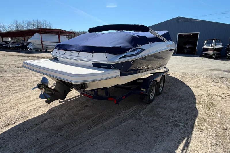 Slide: The Image of 2019 Regal 2300 Bowrider boat on trailer, covered and parked outdoors. - 2