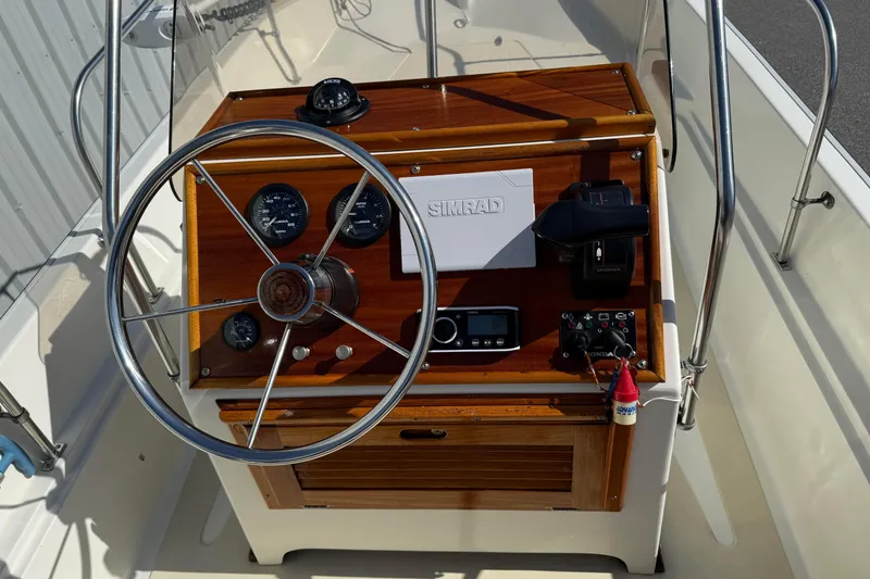 Slide: The Image of 1978 Boston Whaler 17 Montauk boat dashboard with steering wheel and navigation instruments. - 7