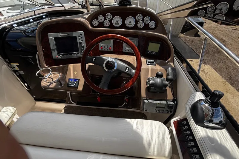 Slide: The Image of 2006 Regal Commodore 3860 helm with wood steering wheel and modern navigation instruments. - 19