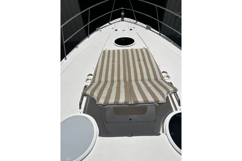 Slide: The Image of 2006 Regal Commodore 3860 yacht deck with striped sunbed and railing. - 30