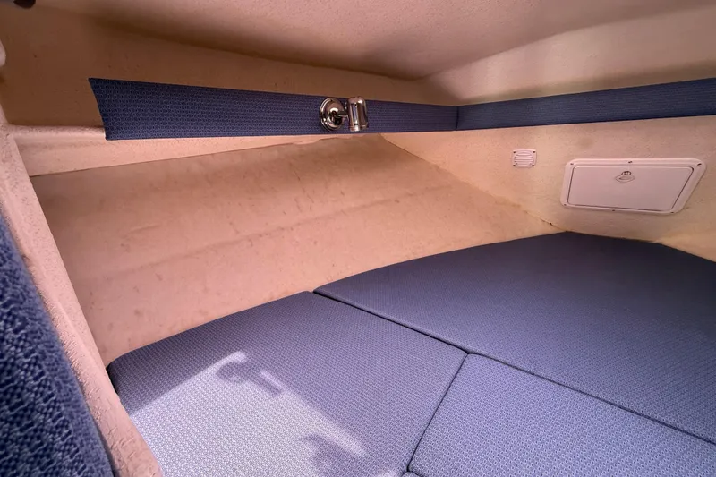 Slide: The Image of Interior cabin of 2005 SeaSport Explorer 2400 with blue cushions and storage compartment. - 10