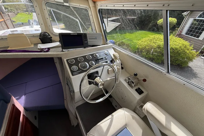 Slide: The Image of Interior of a 2005 SeaSport Explorer 2400 boat with steering wheel and navigation equipment. - 13