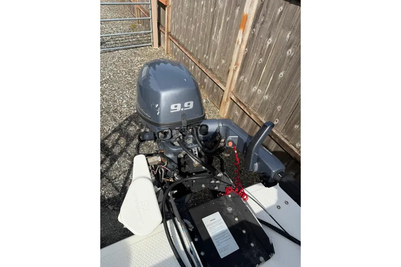Slide: The Image of Outboard motor on a 2005 SeaSport Explorer 2400 boat, wooden fence background. - 16