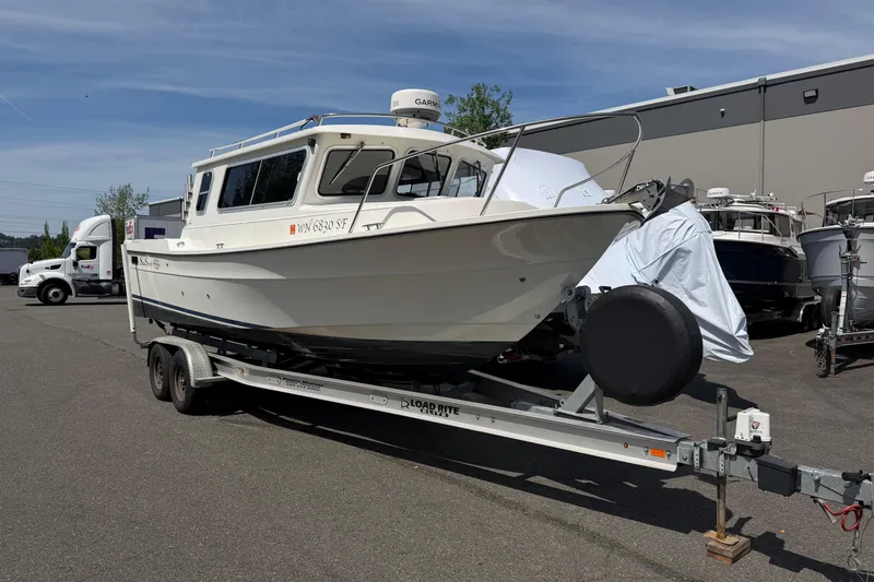 Slide: The Image of 2005 SeaSport Explorer 2400 boat on trailer in parking lot. - 2