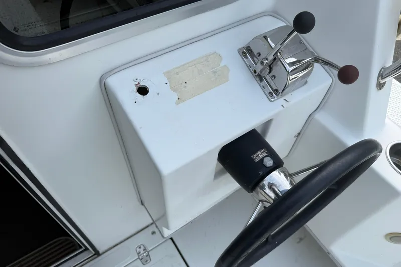 Slide: The Image of Control panel of a 2005 SeaSport Explorer 2400 boat with steering wheel and throttle levers. - 6