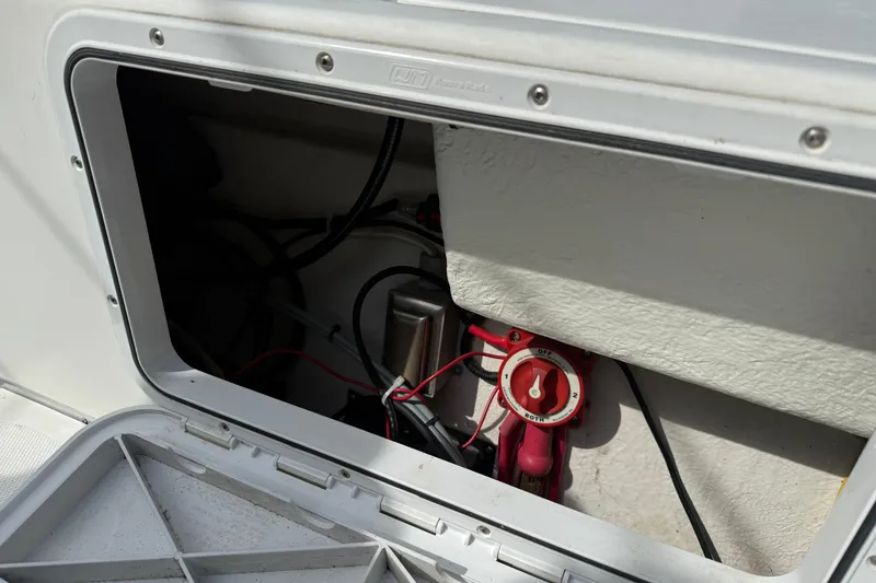 Slide: The Image of Open compartment of a 2005 SeaSport Explorer 2400 showing electrical wiring and switch. - 9