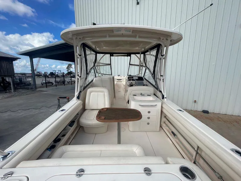 Slide: The Image of 2015 Grady-White Freedom 275 boat interior with seating and table, docked outdoors. - 14