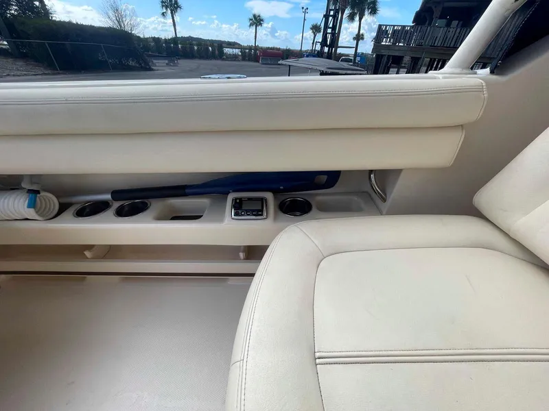 Slide: The Image of Interior of 2015 Grady-White Freedom 275 boat with beige seating and storage compartments. - 15