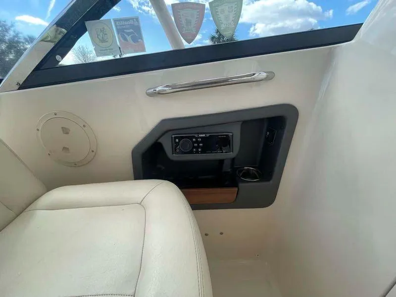 Slide: The Image of Interior view of a 2015 Grady-White Freedom 275 boat, featuring a control panel and seating. - 16