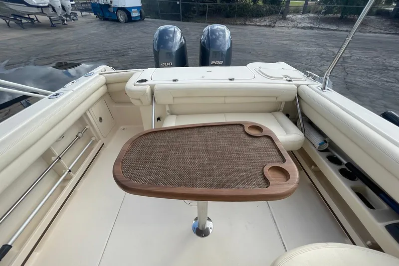 Slide: The Image of 2015 Grady-White Freedom 275 boat interior with table and twin 200 engines. - 19
