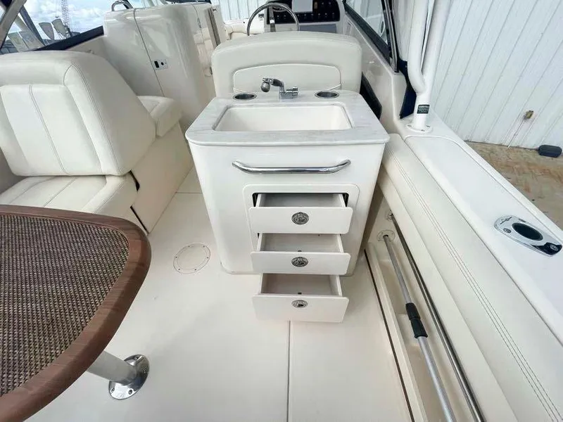 Slide: The Image of 2015 Grady-White Freedom 275 boat interior with sink and storage drawers. - 20