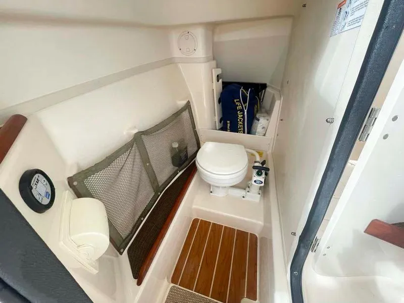 Slide: The Image of 2015 Grady-White Freedom 275 boat interior with compact marine toilet and storage. - 23