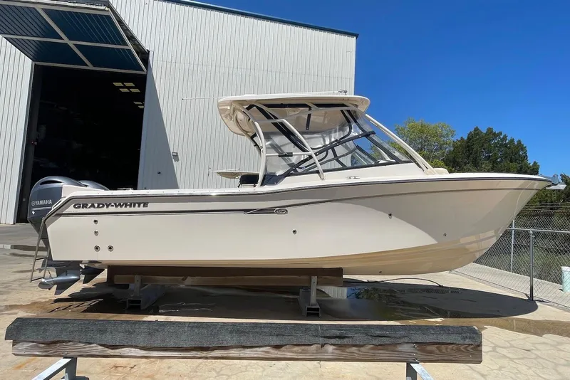 Slide: The Image of 2015 Grady-White Freedom 275 boat on display outside a large warehouse. - 3