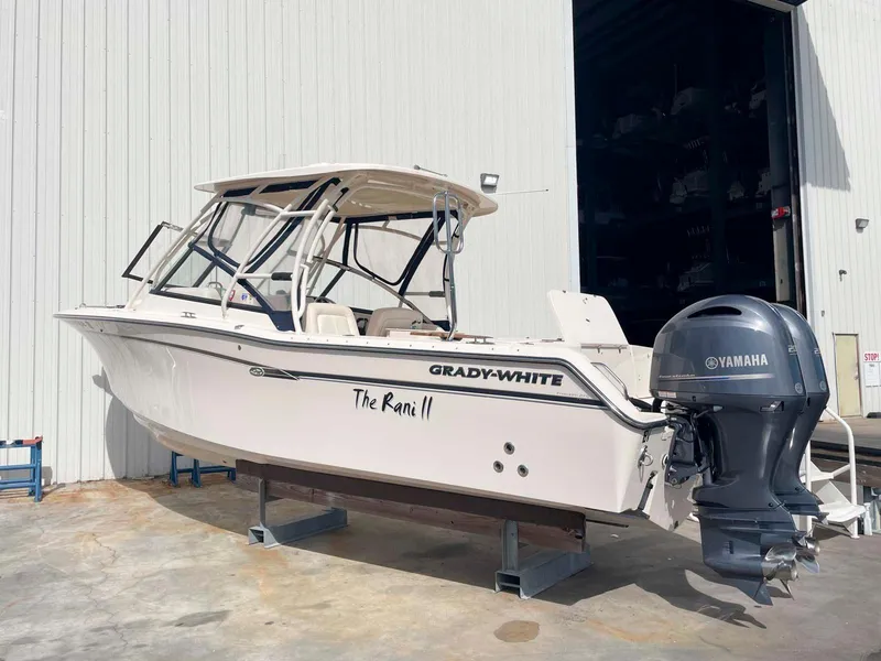 Slide: The Image of 2015 Grady-White Freedom 275 boat with Yamaha engine, docked outside a warehouse. - 4
