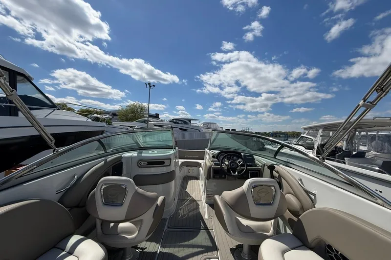 Slide: The Image of 2019 Crownline Eclipse E235 XS boat interior with steering wheel, seating, and clear sky. - 13
