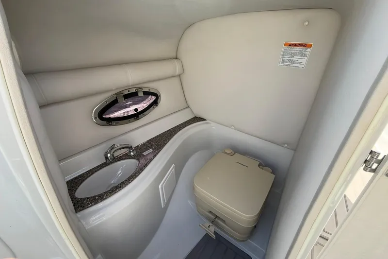Slide: The Image of 2019 Crownline Eclipse E235 XS boat bathroom with sink and portable toilet. - 14
