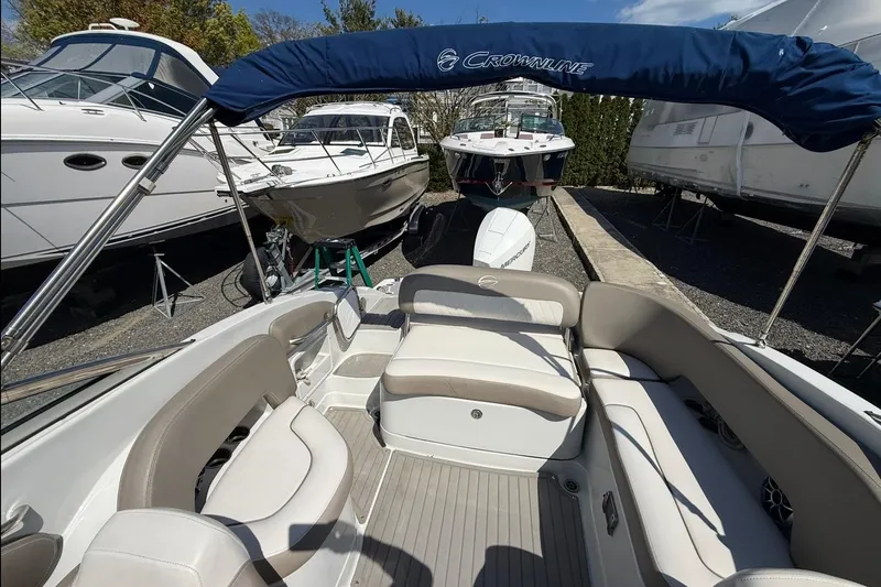 Slide: The Image of 2019 Crownline Eclipse E235 XS boat interior with seating and canopy in marina. - 17