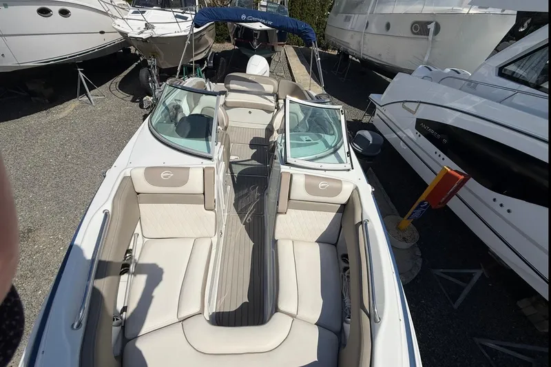 Slide: The Image of 2019 Crownline Eclipse E235 XS boat with spacious seating, docked among other vessels. - 19
