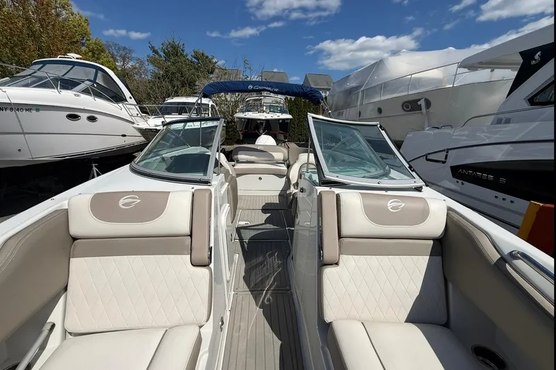 Slide: The Image of 2019 Crownline Eclipse E235 XS boat with beige seating, docked among other boats. - 20