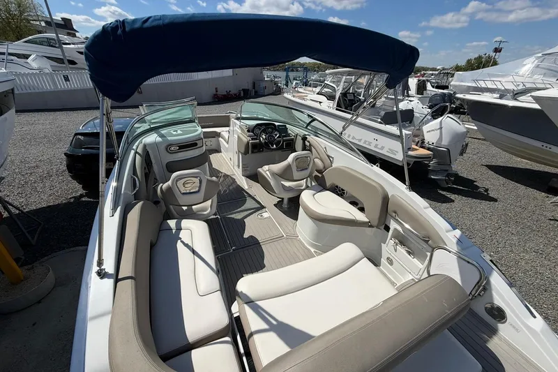Slide: The Image of 2019 Crownline Eclipse E235 XS boat with spacious seating and canopy, docked outdoors. - 23