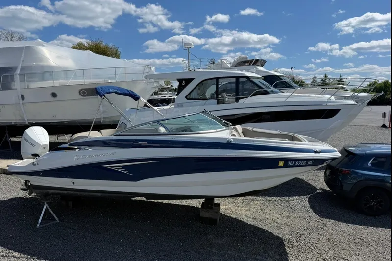 Slide: The Image of 2019 Crownline Eclipse E235 XS boat on display in a marina under a blue sky. - 7