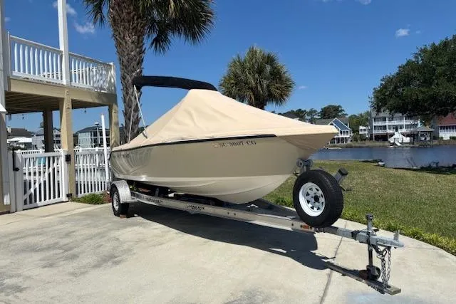 Slide: The Image of 2013 Key West 189 FS boat on trailer, covered, near waterfront homes. - 22